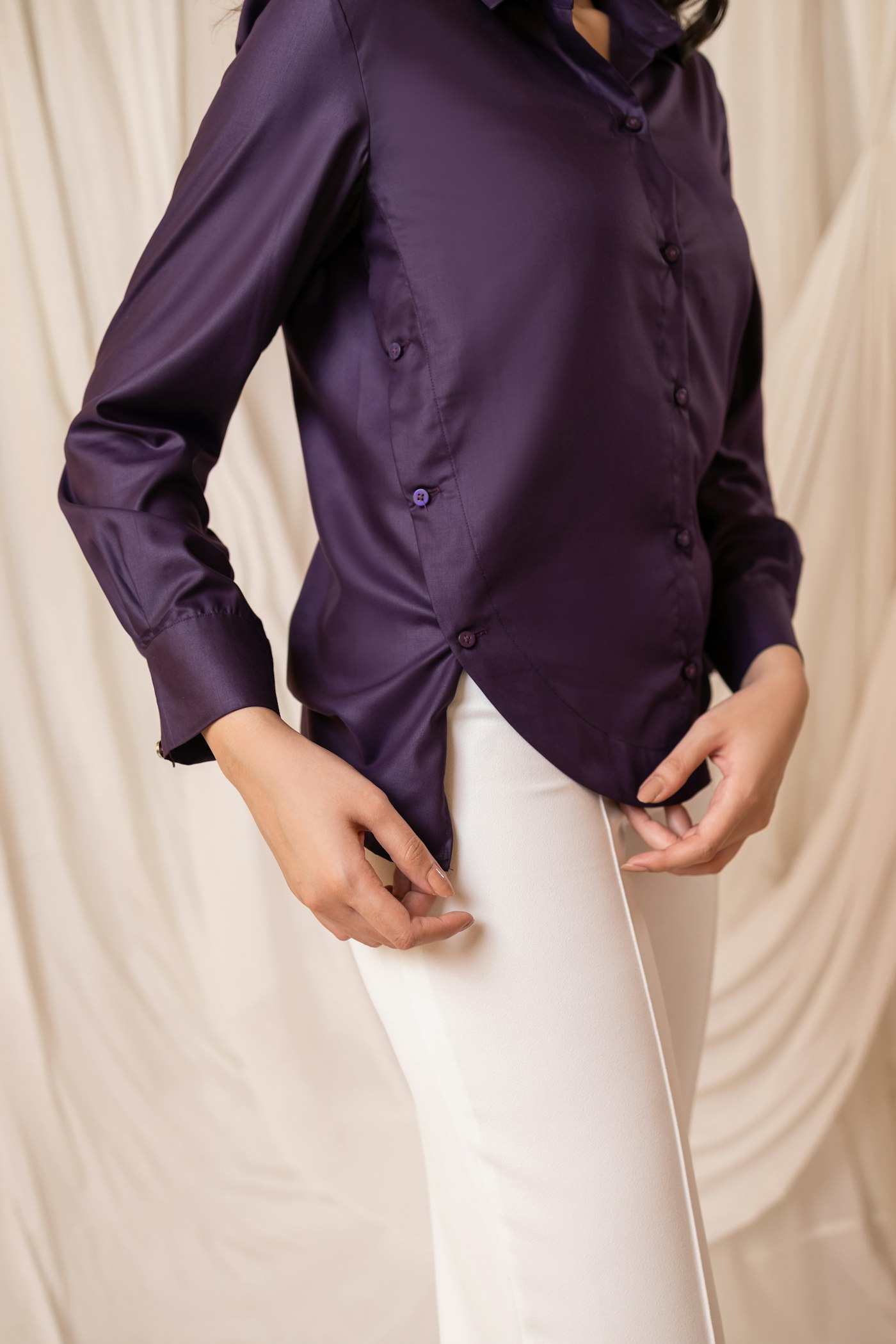 A woman in a silky satin blouse, the drapey look viscose imitates